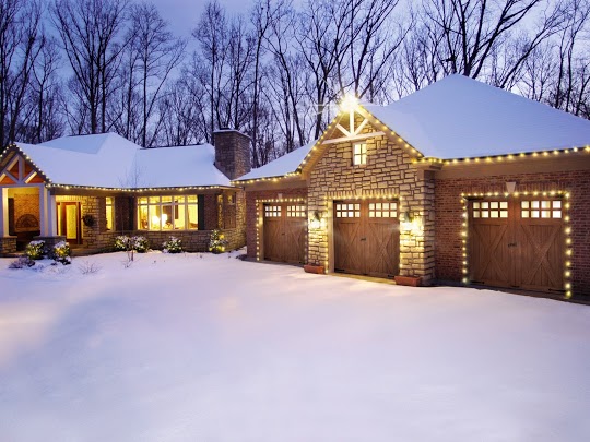 A home with lit up with Christmas lights covered in snow